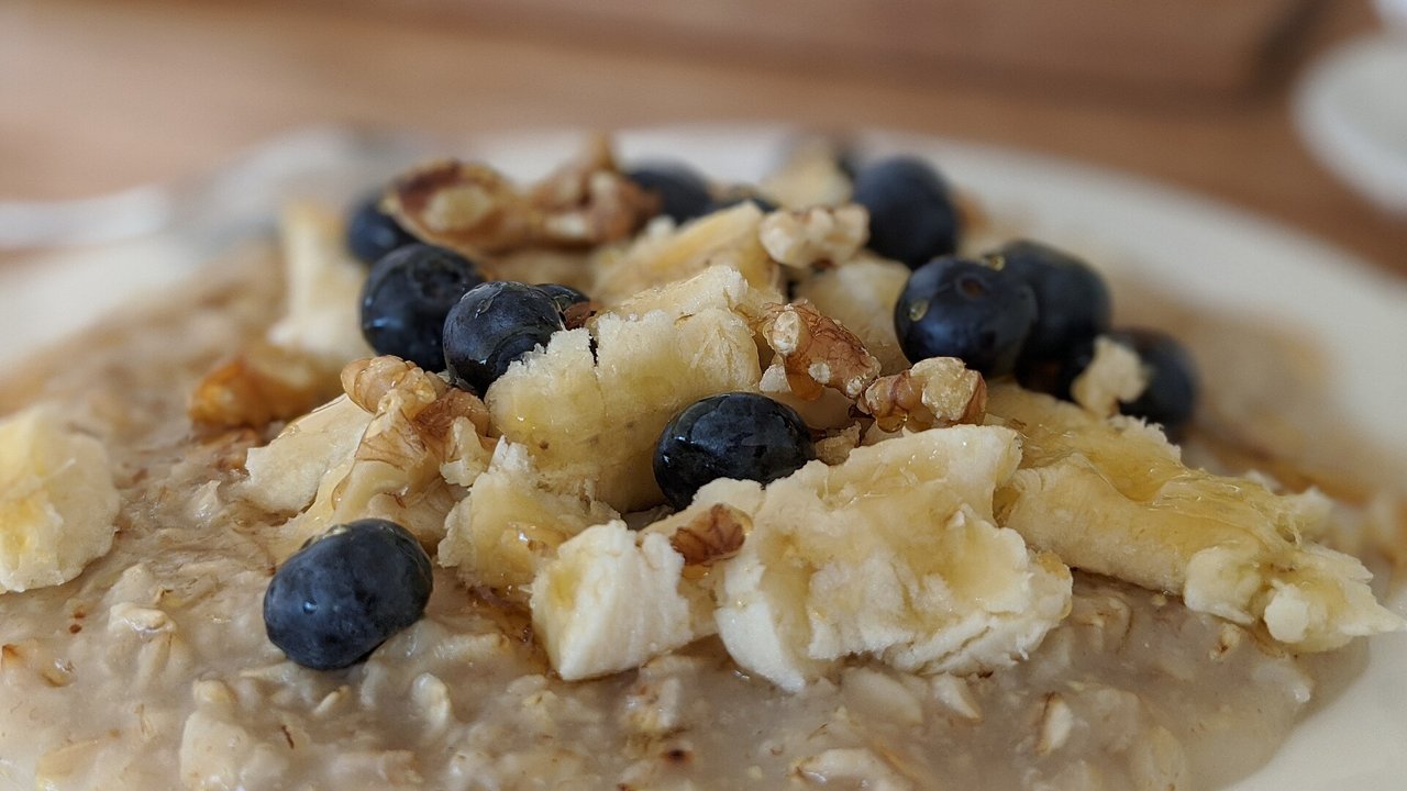 Bowl of oatmeal topped with banana, blueberries and nuts
