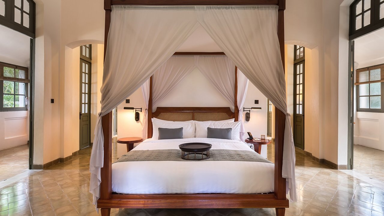 Neatly made bed with white linens in a calm bedroom
